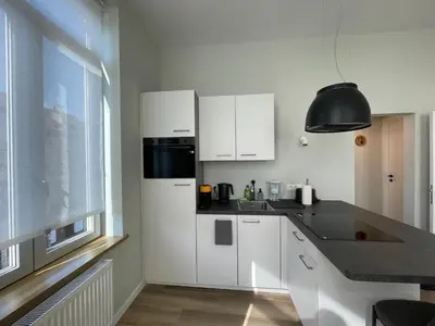 a white kitchen with white cabinets and a window at Midi Station 2 in Brussels