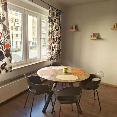 a table and chairs in a room with a window at Splendid 2 bedroom apartment in Etterbeek in Brussels