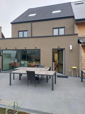 a patio with a table and chairs in front of a house at Krie 2 by Luttelkolen in Tielt