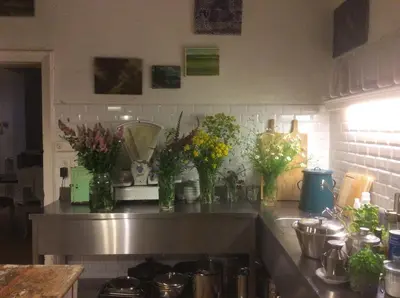 a kitchen counter with several vases of flowers on it at The Secret Garden in Herentals