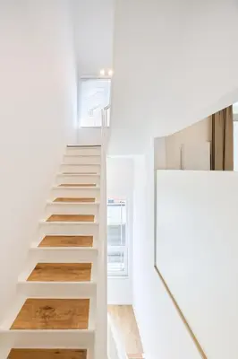 a staircase in a house with white walls and wooden floors at Toison d'Or in Brussels