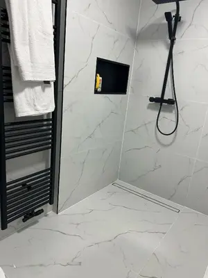a bathroom with a shower with white marble tiles at Luxe Villa Lou & Hans in Aalst