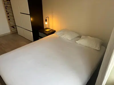 a bedroom with a large white bed and a lamp at Sleep & Explore Brussels in Brussels