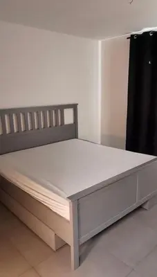 a large bed in a room with a black curtain at Apartment Boom 200m from centrm in Boom