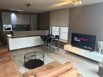 a living room with a couch and a table in a kitchen at Charming apartment in the Heart of Brussels in Brussels