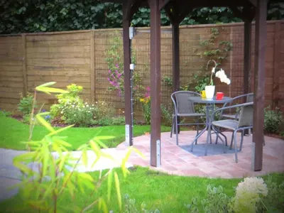 a patio with a table and chairs in a garden at Bed and breakfast Mentari in Ghent