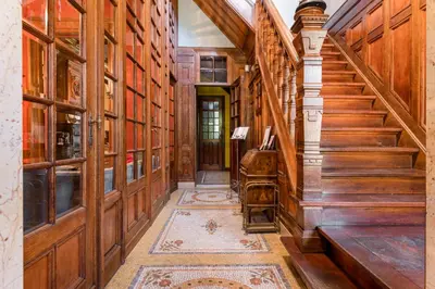 a hallway with wooden walls and a staircase with a rug at Boutique Cogels Osy Suite Four Garden in Antwerp