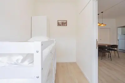 a white bedroom with a bunk bed and a dining room at Chic Antwerp Stay 3BR Comfort in Antwerp