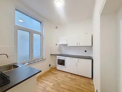 a kitchen with white cabinets and a large window at Basilique Brussels 2 in Brussels