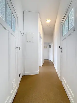 an empty hallway with white walls and doors at Sacre-coeur Brussels 1 in Brussels