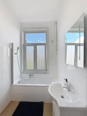 a white bathroom with a sink and a mirror at Sacre-coeur Brussels 1 in Brussels