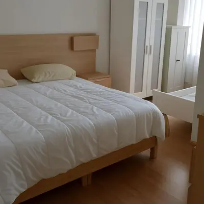 a bedroom with a bed with a white comforter at Belgielei business apartment in Antwerp