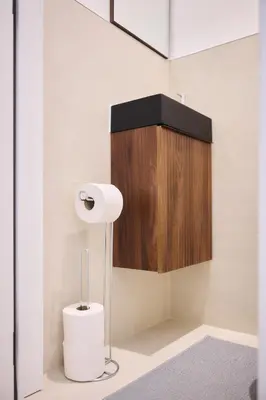 a bathroom with a toilet paper dispenser and a wooden cabinet at Apartment Duden 1 in Brussels