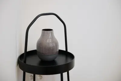 a vase sitting on a black stand on a wall at Apartment Forest Center 2 in Brussels