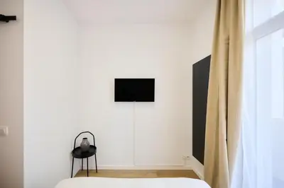 a bedroom with a bed and a television on a wall at Apartment Wiels 3 in Brussels