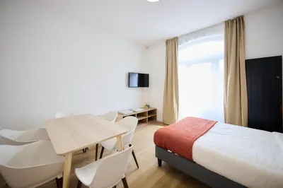 a hotel room with a bed and a table and chairs at Apartment Berthelot 5 in Brussels