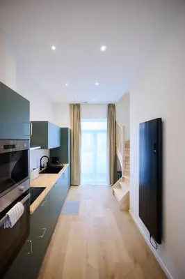 a kitchen with blue cabinets and a black refrigerator at Apartment Berthelot 5 in Brussels