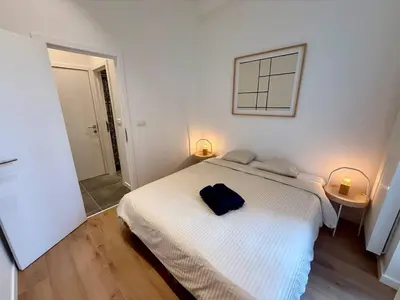a bedroom with a white bed with a blue bag on it at Urban Nest - Brussels in Brussels