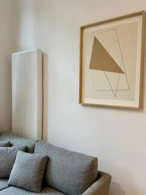 a living room with a couch and a picture on the wall at The Modern Nest - Jourdan in Brussels