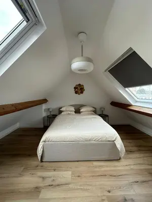 a white bedroom with a bed and two windows at 3- Duplex Lumineux au coeur d'Ixelles in Brussels