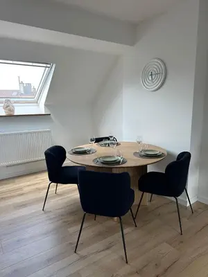 a dining room table with four chairs and a window at 3- Duplex Lumineux au coeur d'Ixelles in Brussels