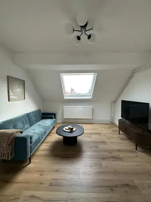 a living room with a blue couch and a table at 5- Nid lumineux 2 chambres au plein coeur d'Ixelles in Brussels