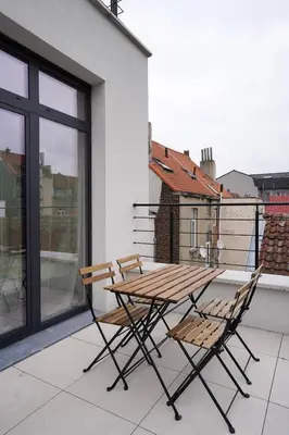 a wooden table and two chairs on a balcony at Appartment Jacobs 6 in Brussels