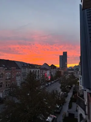 a view of a city at sunset at Modern 2-Bedroom Apartment for 4 Guests, In a Prime Location Close to the Train Station and the Historic Center of Ghent in Ghent
