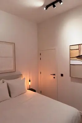 a bedroom with a white bed and a door at Modern 2-Bedroom Apartment for 4 Guests, In a Prime Location Close to the Train Station and the Historic Center of Ghent in Ghent