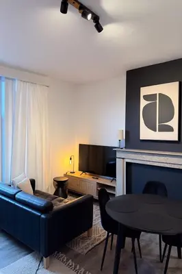 a living room with a couch and a table at Modern 2-Bedroom Apartment for 4 Guests, In a Prime Location Close to the Train Station and the Historic Center of Ghent in Ghent