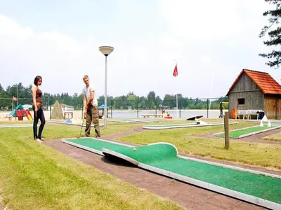 two people standing next to a skateboard ramp in a park at Luxury Forest Lodge with Private Garden in Ravels