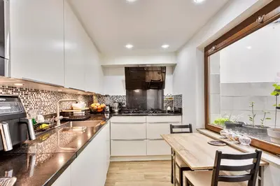 a kitchen with white cabinets and a wooden table at Chambres dans un Immeuble in Brussels