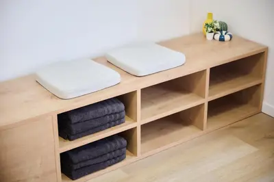 a wooden shelf with three towels on top at Apartement Berthelot 5 in Brussels