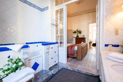 a bathroom with a tub and a sink and a bed at Papillon Boutique Villa Centre Antwerp in Antwerp