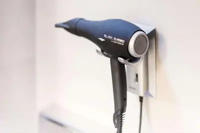 a hair dryer is attached to a wall at NH Brussels Stéphanie in Brussels