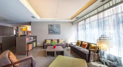 a living room with a couch and a table at Hotel Rastelli Tervuren in Tervuren