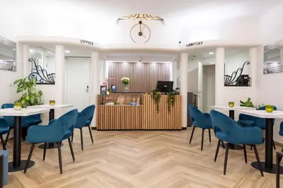 a room with tables and chairs and a clock on the wall at Hotel Le Grand Colombier in Brussels