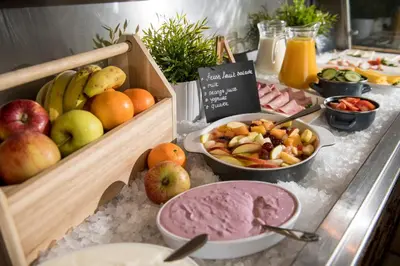 a buffet with fruits and other food on a table at Campanile Hotel & Restaurant Brussels Vilvoorde in Vilvoorde