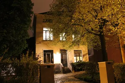 a white house with a tree in front of it at B&B Le Verger in Brussels