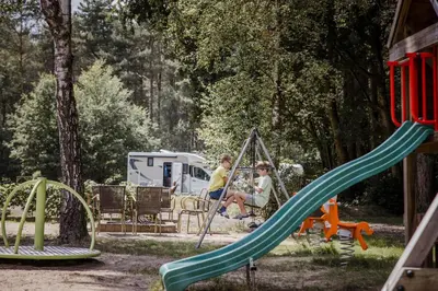 two people sitting on a swing at a playground at Camping Siësta in Lille