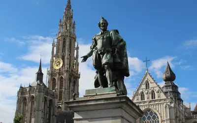 a statue in front of a building with a clock tower at Noir Loft with Skyline View in Antwerp