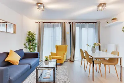 a living room with a couch and a table and chairs at Royal Arts-Loi Studio in Brussels