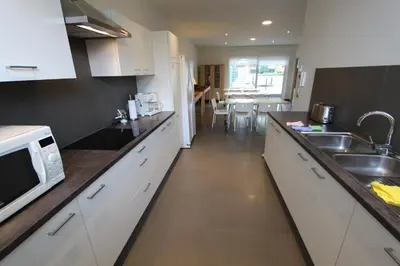 a kitchen with white cabinets and a sink and a microwave at NUVOLA HOUSE in Zottegem