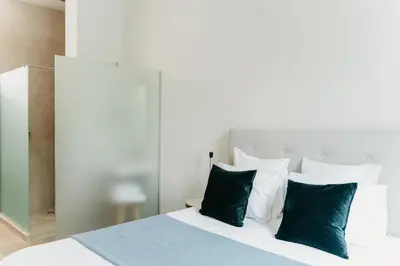 a bedroom with a bed with green and white pillows at The 1880 Boutique Holiday Home in Antwerp