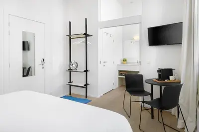 a bedroom with a bed and a table and chairs at The 1880 Residence by Domani Hotels in Antwerp