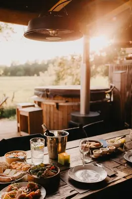 a wooden table with plates of food on it at ASILI DELUXE - Zebra in Lichtaart