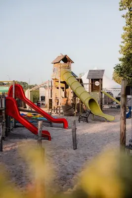 a playground with a slide in front of a building at POLE POLE - Ijsbeer in Lichtaart