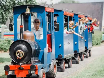 a group of children riding on a small train at Chalet near Antwerp with Pool Access in Rijkevorsel