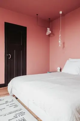 a bedroom with a white bed and a pink wall at Huis Hector Mechiels ROOM in Sint-Niklaas