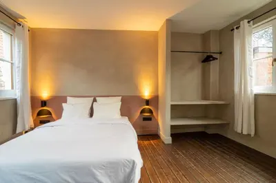a bedroom with a white bed and two lamps at Charming House in Le Sablon in Brussels